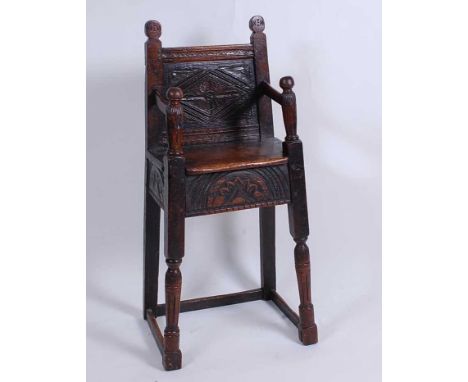 A circa 1700 joined oak correction chair, having a lozenge carved panel back and sunburst carved apron, turned and fluted squ