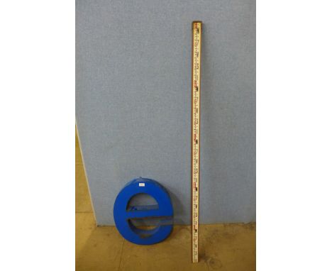 A surveyor's measuring stick and a metal e shop letter