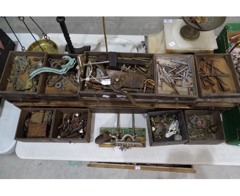 A collection of antique locks, fittings, large brass screws and miscellaneous items, within a Georgian tool box fitment, incl
