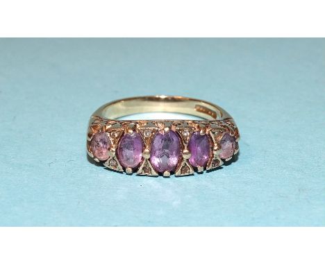 A 9ct gold ring set five graduated amethysts and diamond points, size N, 4.8g. 