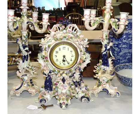 A 20th century ceramic clock set, comprising a clock with applied figures, cherubs and floral decoration, 39cm high and a pai
