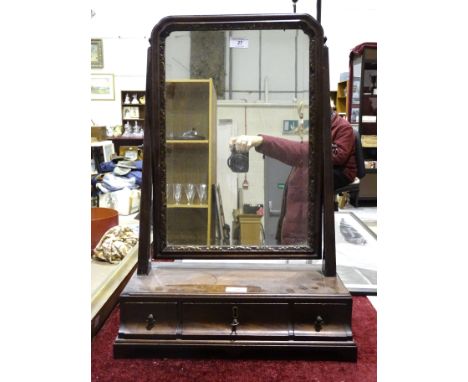 A Georgian mahogany dressing glass, the swing mirror above three drawers, raised on bracket feet, 64cm high, 34cm wide. 