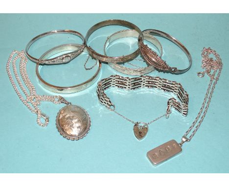 Five various silver bangles, a silver gate-link bracelet, a silver locket on chain, 130g and an ingot on chain, (8). 
