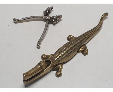 An brass alligator form nutcracker with one other