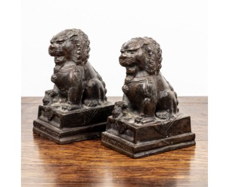 Pair of small bronze models of temple dogsChinese, each modelled in the Ming style, on rectangular bases, 12cm high  With som