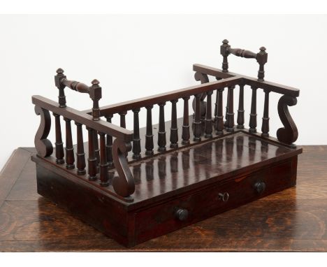 In the manner of Gillows rosewood, double sided book carrier, with turned balustrade columns, fitted with a large drawer, 44.