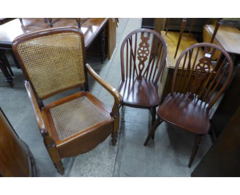 A pair of beech wheelback chairs and a mahogany bergere commode chair 