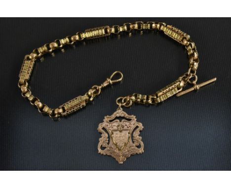 A Victorian/Edwardian heavy weight fancy link 9ct gold Albert chain, ornate shaped and faceted links, T bar top, suspending a