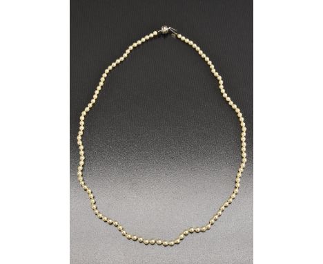 A single strand individually knotted cultured pearl necklace, uniform pearls each approx 3.3mm diameter, JKa 14ct white globe