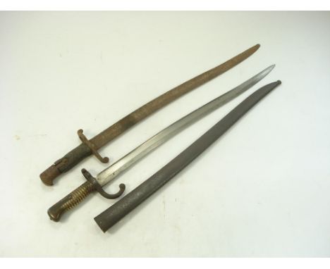 A French Chassepot bayonet:, curved blade with steel hilt and single quillon , reeded brass grip in a steel scabbard with mat
