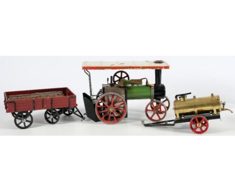 A Mamod live steam traction engine:, in white and green with red spoked wheels, together with a brass water carrier and a red
