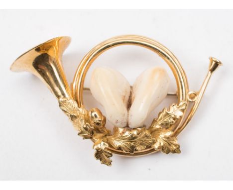 A hunting brooch in the form of a bugle:,  comprising two stag teeth, the reverse stamped '750', approximately 50mm long over