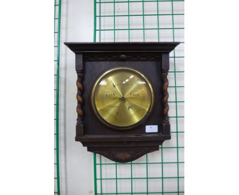 An early 20th Century carved oak barleytwist aneroid barometer 