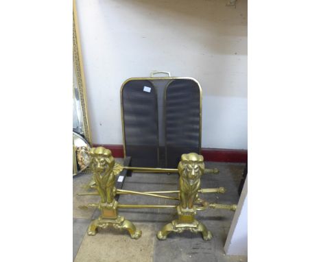 A pair of brass and cast iron andirons, fire screen and a companion set 
