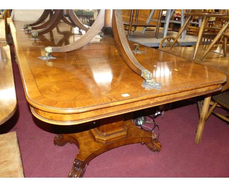 A contemporary figured walnut and crossbanded round-cornered twin pillared dining table, having two extra drop-in leaves, the