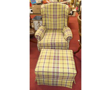 A walnut framed and chequer fabric upholstered wingback scroll armchair, with matching footstool on roller castors (2)