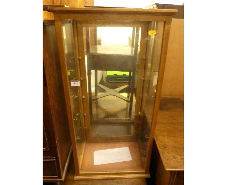 A light oak table top shop display cabinet, having rear door and adjustable glass interior shelves, 75.5 x 38 x 25.5cm