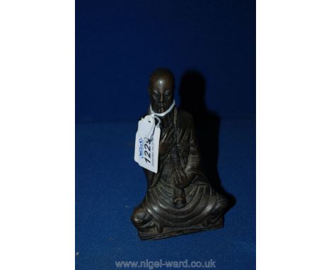 A Figure of a Tibetan Monk Seated in Lotus Position Playing a Dbang Dung - 5" high.