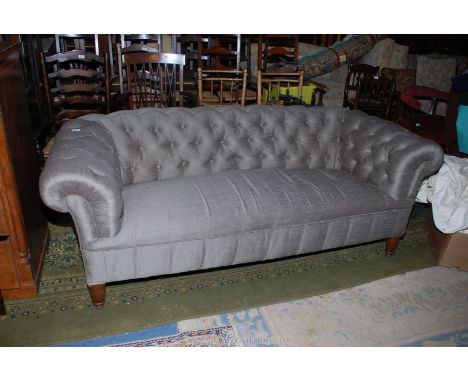 A good Victorian Chesterfield Settee having button upholstered back and scroll arms, standing on turned Oak legs