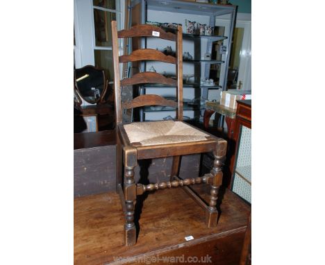 A 1940's Oak ladder back Dining Chair with four shaped rungs to the back, drop-in rush seat and standing on turned legs with 