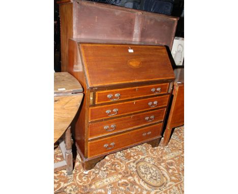An Edwardian Mahogany Bureau having cross-banded top over the inlaid butterfly motif fall, opening to reveal six pigeonholes 