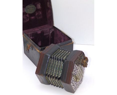 An old rosewood concertina with fretwork style nickel plated ends having 28 button keys each, numbered 41519, in square leath