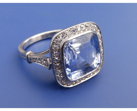 An art deco style certified Sri-Lankan cornflower blue sapphire &amp; diamond cluster ring, the square step cut sapphire weig