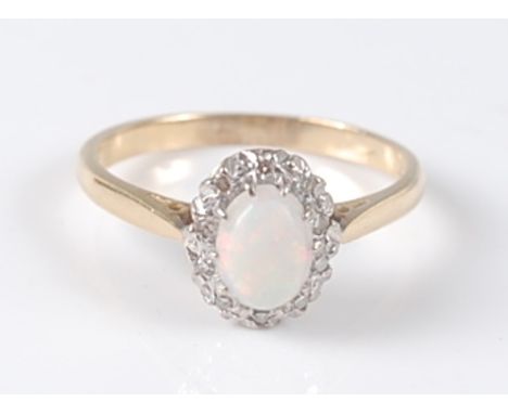 An 18ct yellow and white gold, opal and diamond oval cluster ring, the centre white opal cabochon measuring approx 7 x 5.1 x 