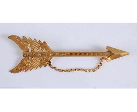 A yellow metal engraved bar brooch in the form of an arrow , with a safety chain, length 105mm, gross weight 10.5g, not hallm