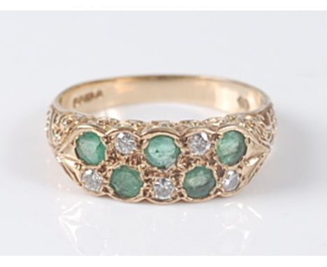 A 9ct yellow gold, emerald and diamond carved head two row half hoop eternity ring, comprising five round emeralds alternatin