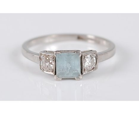 A stamped platinum, aquamarine and diamond three-stone ring, the ring comprising a step cut aquamarine with an old cut diamon