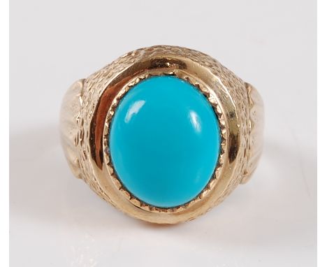 A 9ct yellow gold signet ring with an oval turquoise coloured cabochon, in a bezel setting, with engraved hollow shoulders, s