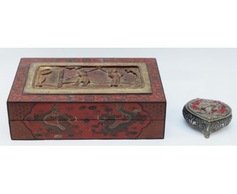 A large oriental retangular cinnabar lacquer box and carved cover, inlaid throughout with dragons, temple lions and flowers, 