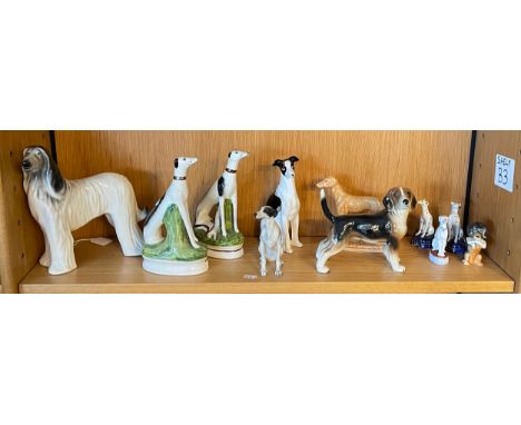 A collection of 20th century ceramic models of dogs, to include two pairs of Staffordshire ware seated greyhounds, largest 23