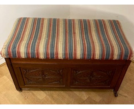 A mahogany camphor/bedding chest, having upholstered hinged top above carved floral panels to all sides, raised on ceramic ca