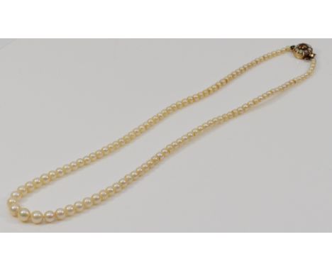 A single row, graduated cultured pearl necklace, 7 - 2.5mm beads, 49cm, to a 9ct gold garnet and pearl three row clasp.