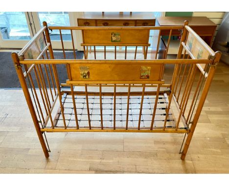 A vintage beech childs cot, complete with sprung base on castors, 122x64cm.