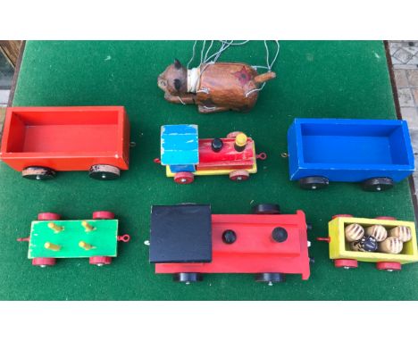 Lot of wooden toys including two tractors, four trailers and a wooden cat puppet.Condition ReportPlayworn, some paint has chi