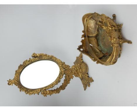 Cherub and cupid dressing table oval metal mirror with scallop pin tray, 41cm h., and an oval rococo style acanthus decorated