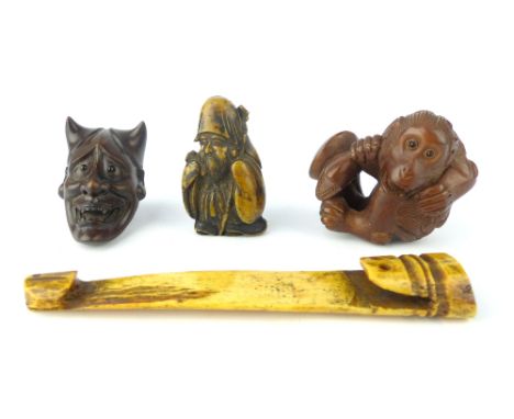 Two hardwood netsukes of monkey and mask, a stag antler and resin netsuke.