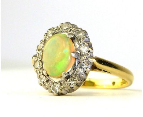 18ct yellow gold and platinum opal ring, the central claw set stone with diamond border.