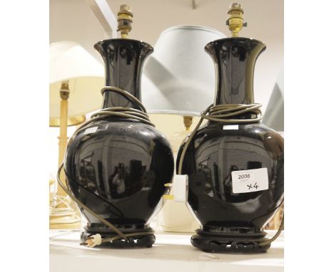 Pair of black ceramic baluster form table lamps, on Chinese style wooden carved bases, a squat form Chinese style blue and wh
