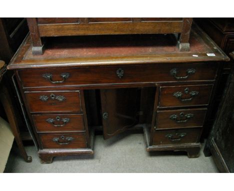 An 18th century George III mahogany desk, the top with an inset leather, above drawers with a double door cupboard to the Kne