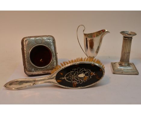 Four silver items comprising a Birmingham helmet shaped jug, a candlestick, watch case and hairbrush