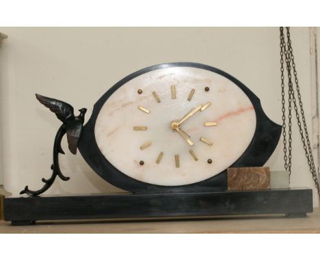 An Art Deco onyx type mantle clock of oval shape applied with a bird to one side. Approximately 51x26cm high