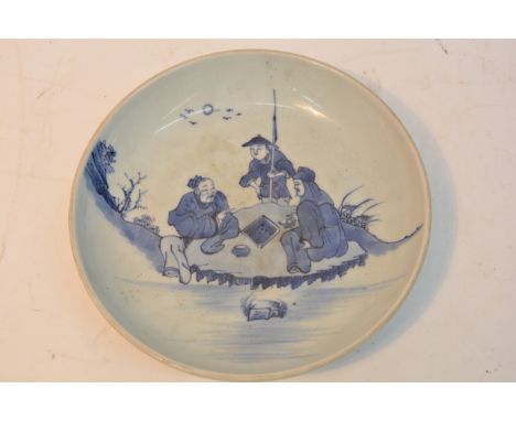 A Chinese blue and white plate decorated with three figures playing a game. Diameter 29cm approximately