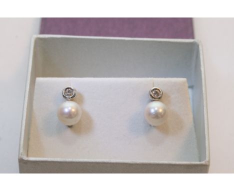 A pair of 18ct white gold diamond and pearl set stud earrings