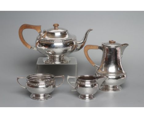 AN ARTS AND CRAFTS FOUR PIECE TEA SERVICE, maker A.E. Jones, Birmingham 1922, of squat globular form on a low foot, the cast 