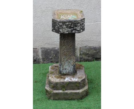 A SANDSTONE BIRD BATH, the finely cut canted square basin raised on tapering stem and stepped canted square base, 17" x 33 1/