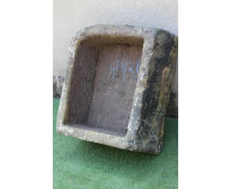 A SANDSTONE TROUGH of rough hewn deep oblong form with one rounded corner, 28 1/4" x 24" x 13" (Est. plus 24% premium inc. VA